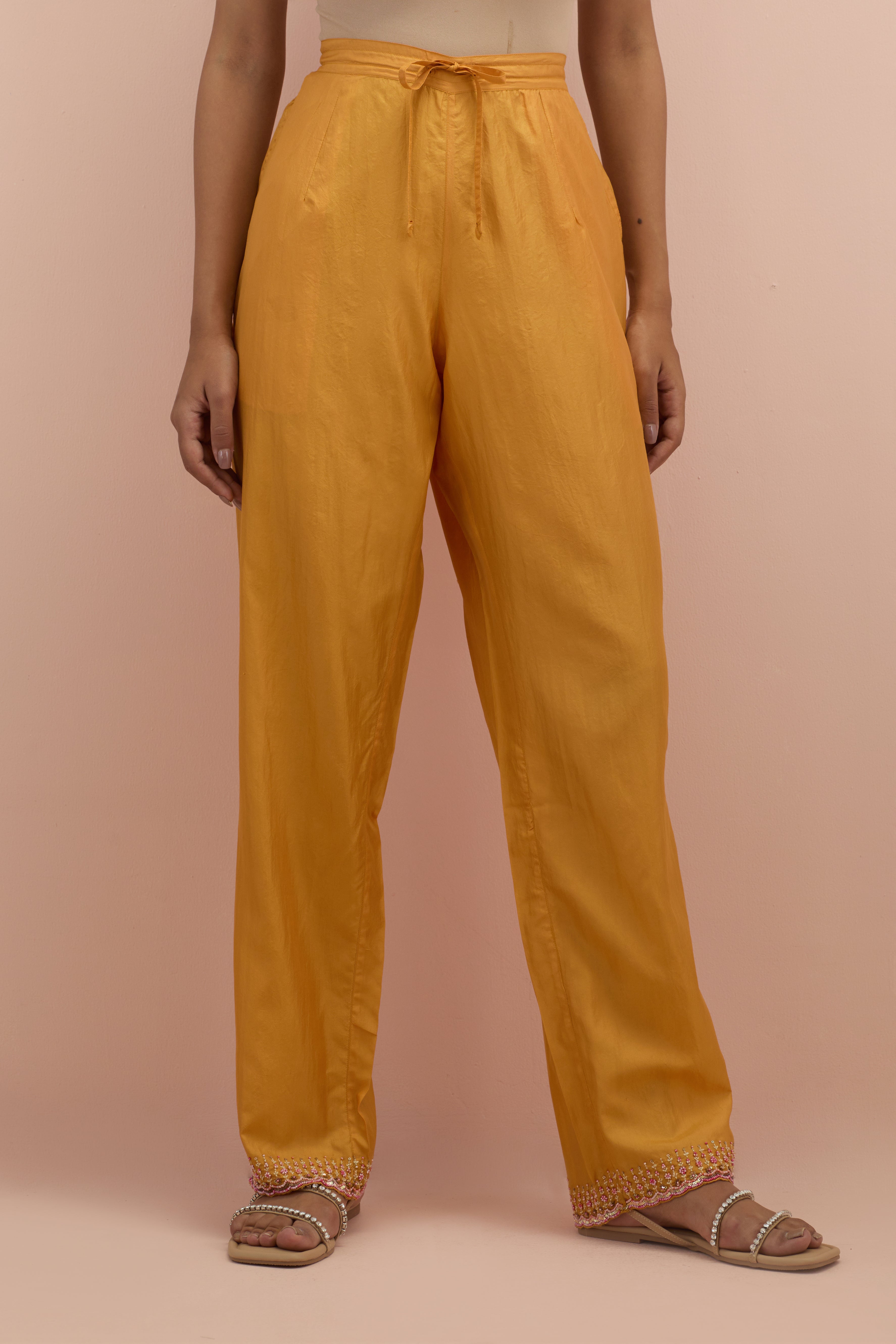 Amber silk straight pants with sequins and multi-colored beadwork at hem.