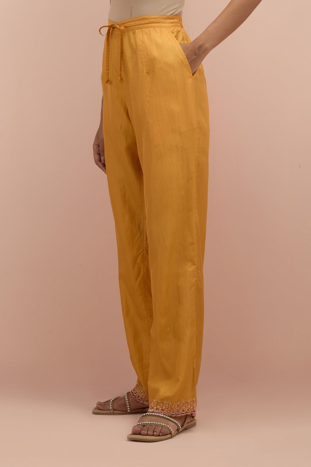 Amber silk straight pants with sequins and multi-colored beadwork at hem.