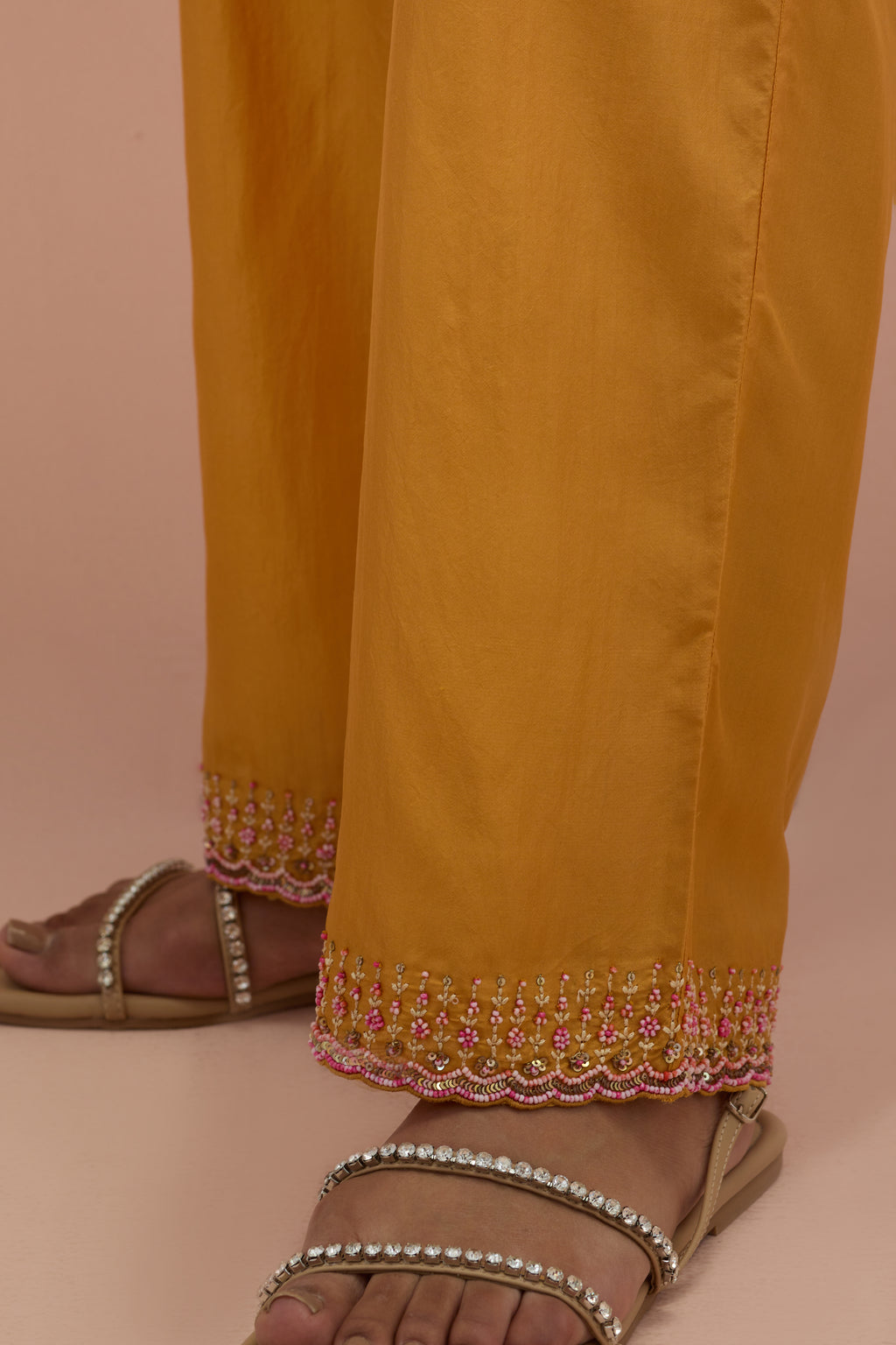 Amber silk straight pants with sequins and multi-colored beadwork at hem.