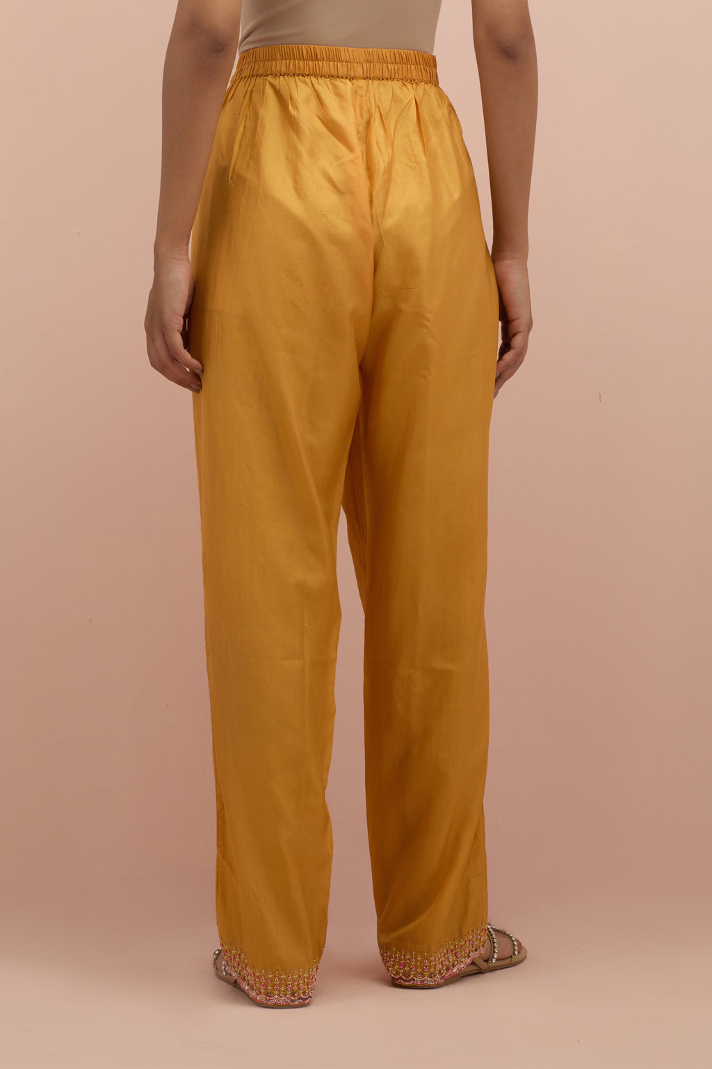 Amber silk straight pants with sequins and multi-colored beadwork at hem.