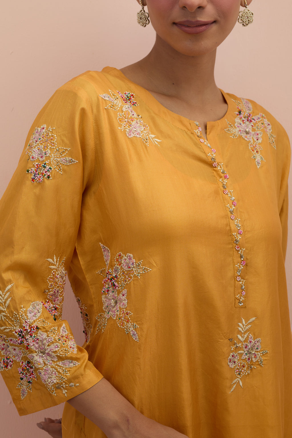 Amber silk straight kurta set with all-over hand block printed appliqué motifs, highlighted with sequins and multi-colored beads.