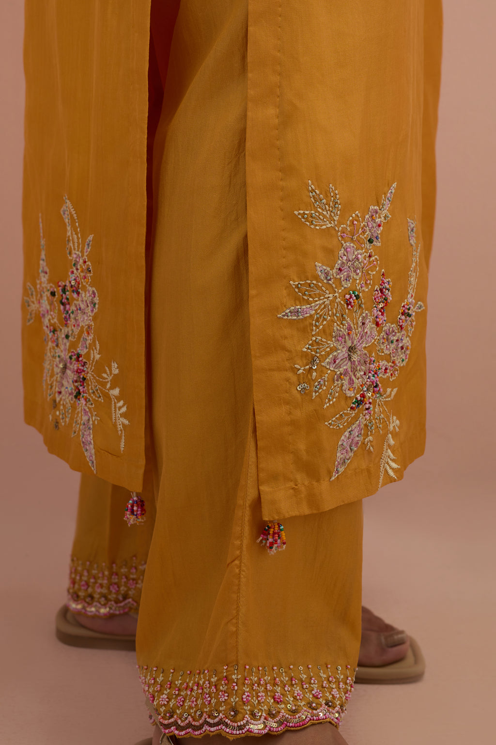 Amber silk straight kurta set with all-over hand block printed appliqué motifs, highlighted with sequins and multi-colored beads.