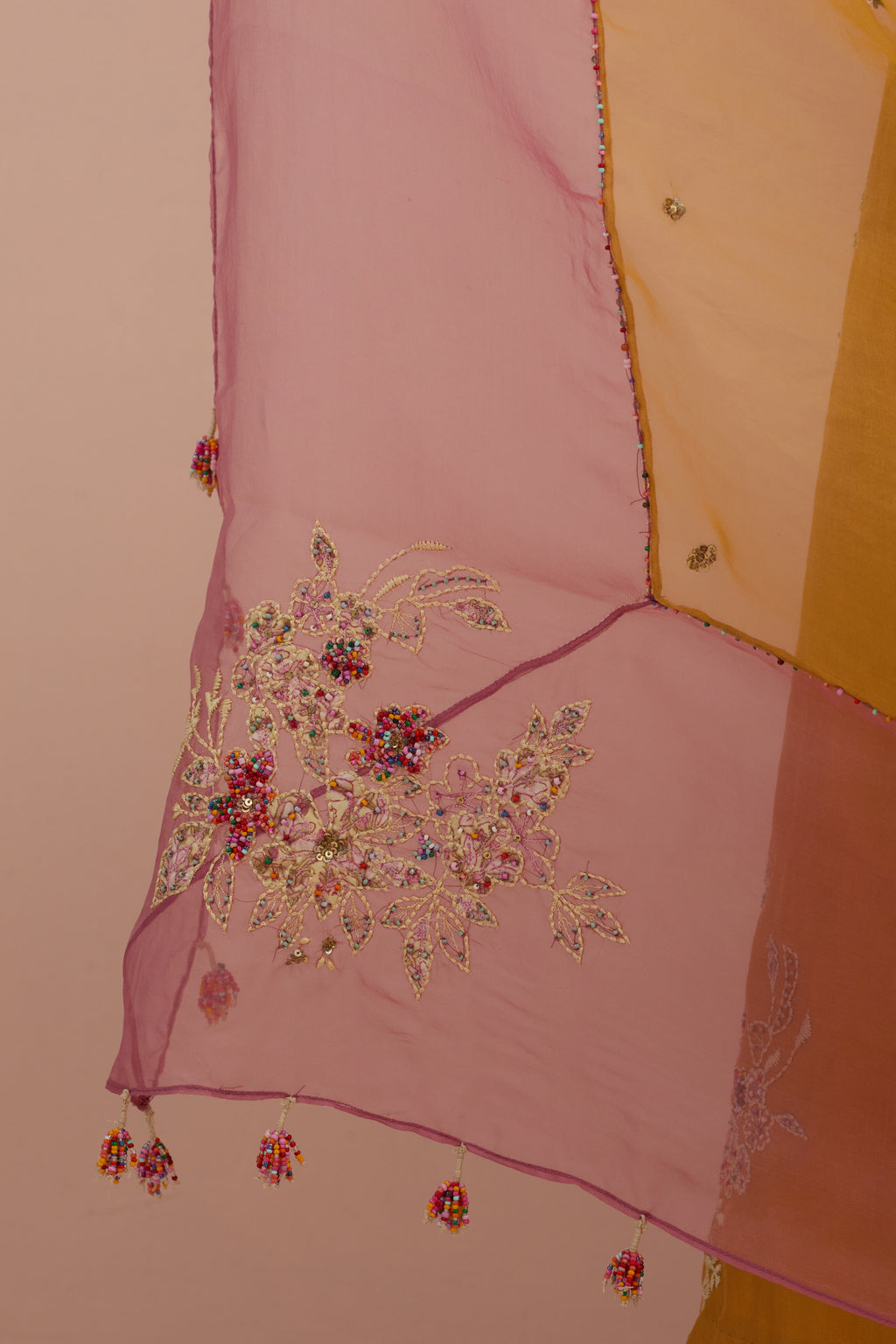 Amber & salmon pink silk organza narrow dupatta, highlighted with all-over delicate sequins flower and hand block printed appliqué motifs at dupatta corners.