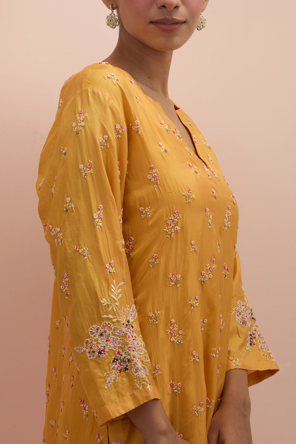 Amber silk straight kurta set with all-over delicate embroidered flowers, highlighted with sequins and multi-colored beads.