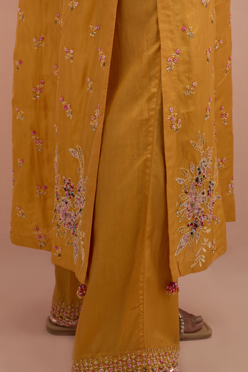 Amber silk straight kurta set with all-over delicate embroidered flowers, highlighted with sequins and multi-colored beads.