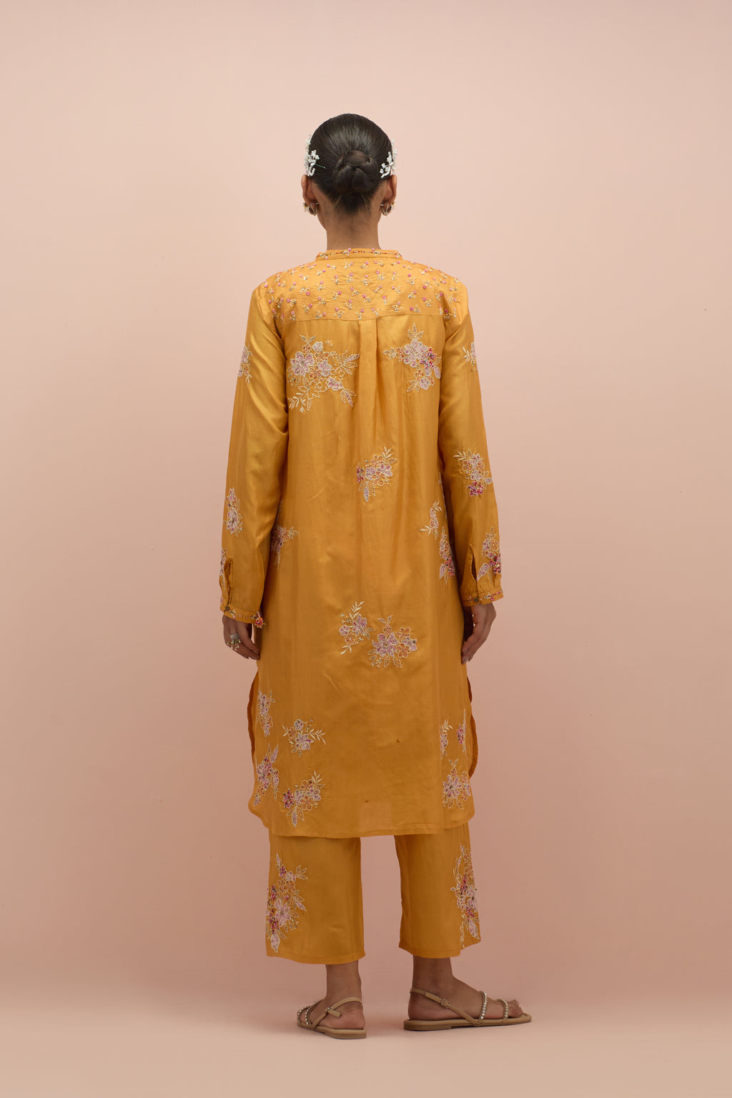 Amber silk short shirt kurta with all-over hand block printed appliqué, highlighted with sequins and multi colored beads, paired with amber silk ankle length straight pants with hand block printed appliqué motifs at the sides.