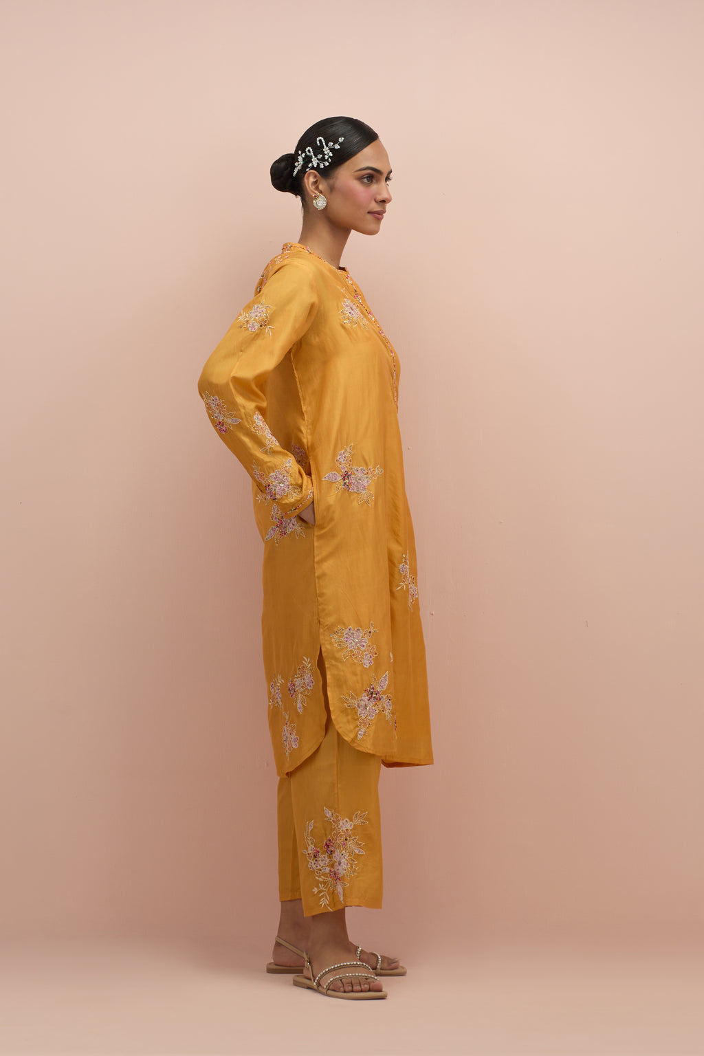 Amber silk short shirt kurta with all-over hand block printed appliqué, highlighted with sequins and multi colored beads, paired with amber silk ankle length straight pants with hand block printed appliqué motifs at the sides.