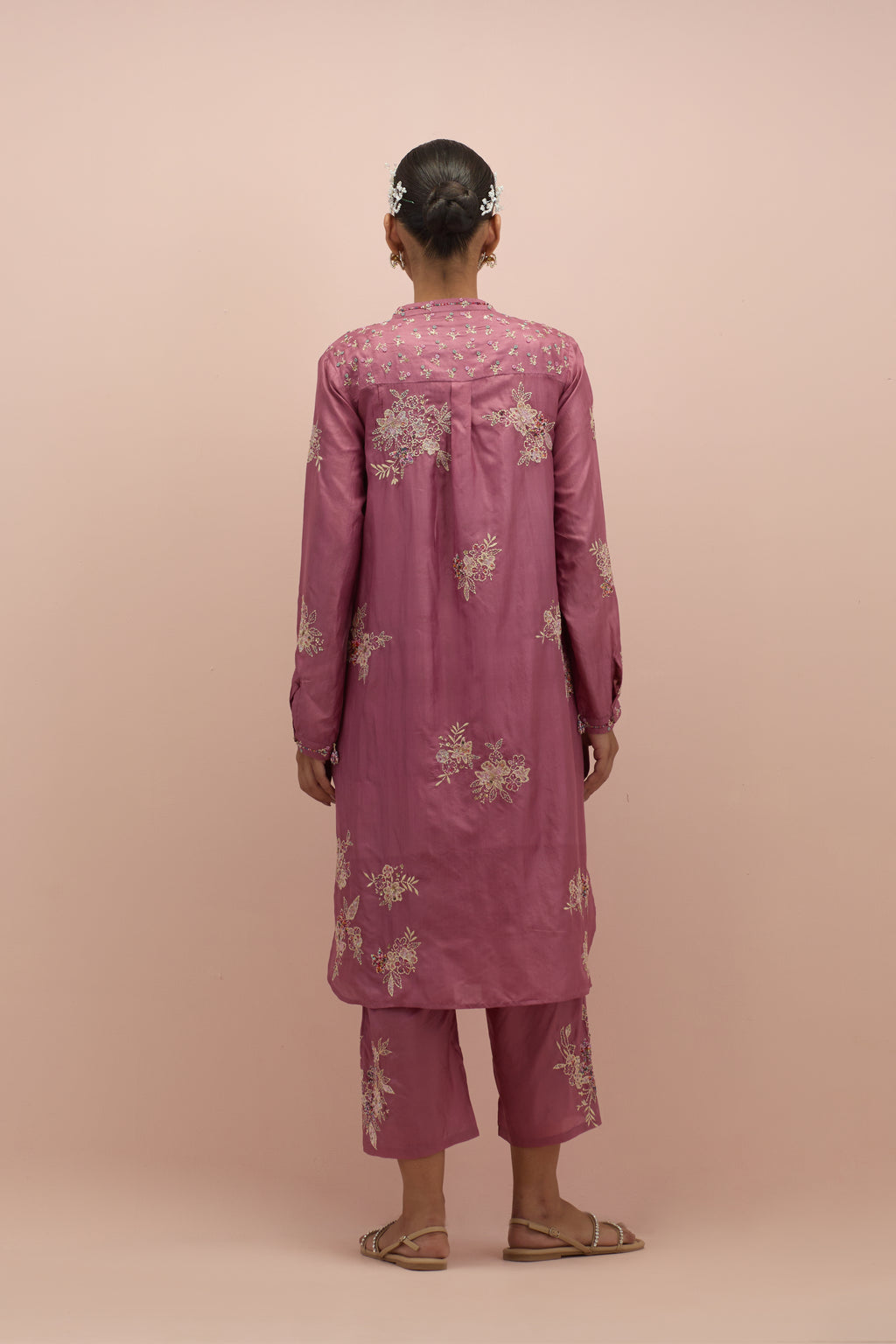 Salmon pink silk short shirt kurta with all-over hand block printed appliqué, highlighted with sequins and multi colored beads, paired with Salmon pink silk ankle length straight pants with hand block printed appliqué motifs at the sides.