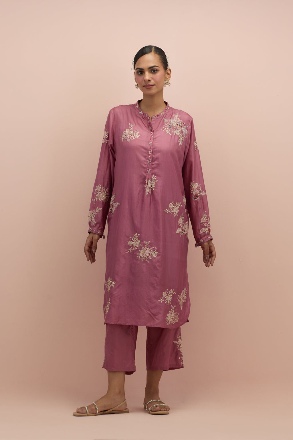 Salmon pink silk short shirt kurta with all-over hand block printed appliqué, highlighted with sequins and multi colored beads, paired with Salmon pink silk ankle length straight pants with hand block printed appliqué motifs at the sides.