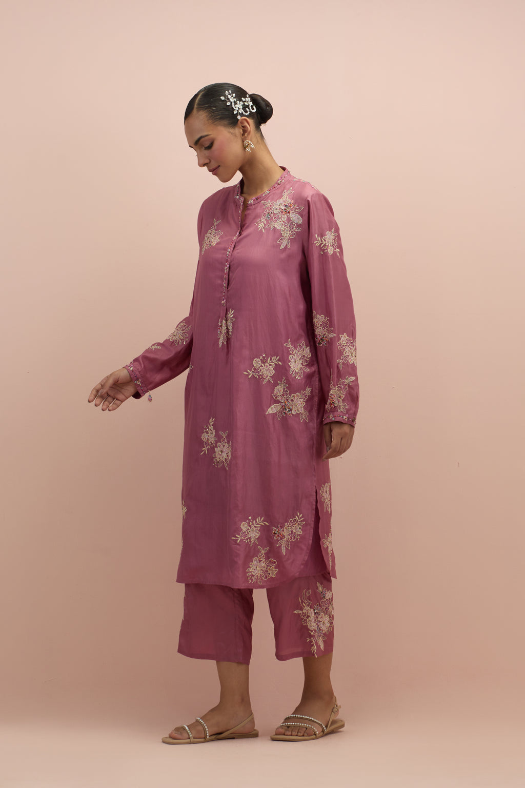 Salmon pink silk short shirt kurta with all-over hand block printed appliqué, highlighted with sequins and multi colored beads, paired with Salmon pink silk ankle length straight pants with hand block printed appliqué motifs at the sides.