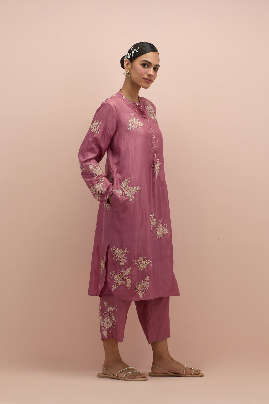 Salmon pink silk short shirt kurta with all-over hand block printed appliqué, highlighted with sequins and multi colored beads, paired with Salmon pink silk ankle length straight pants with hand block printed appliqué motifs at the sides.