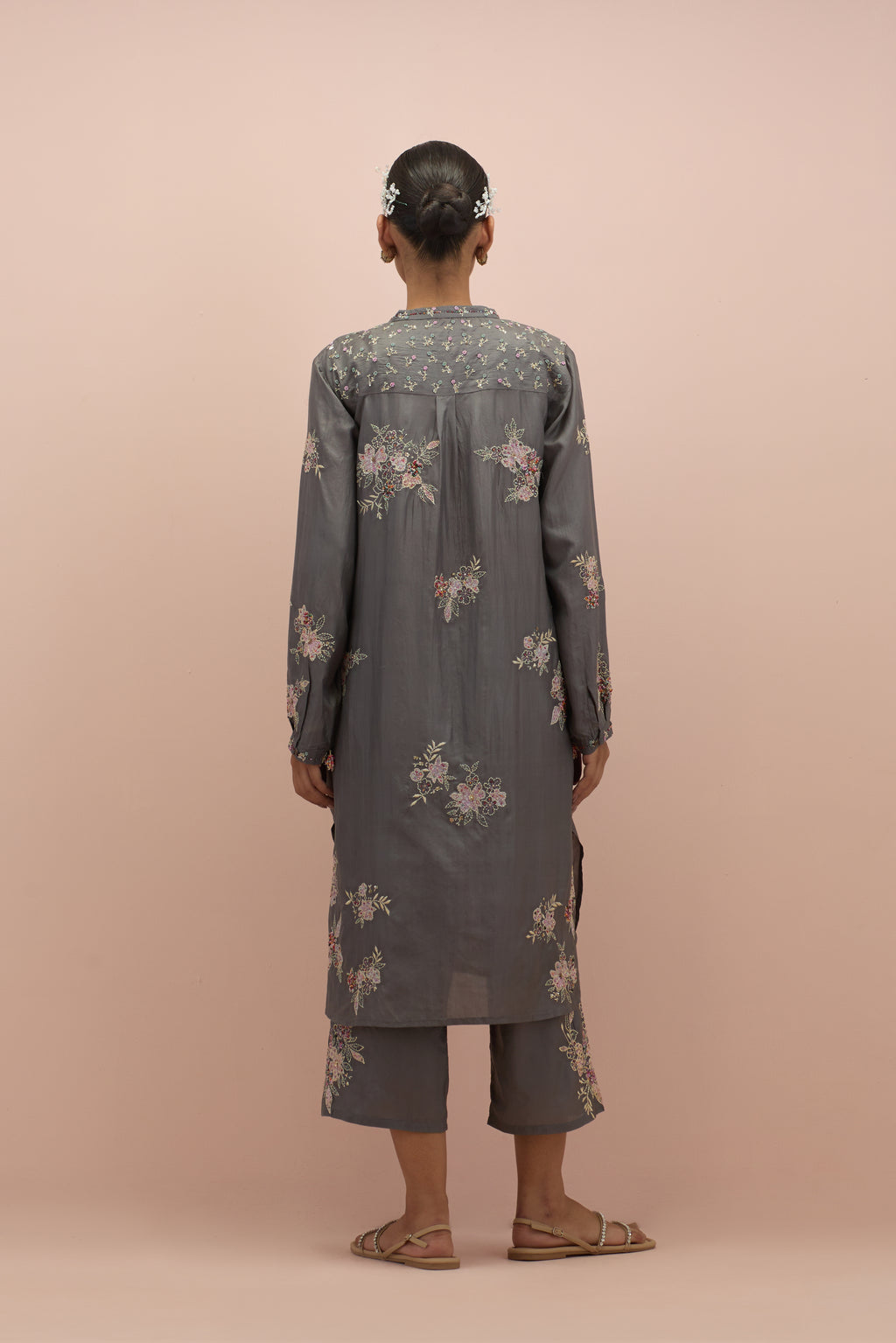 Iron grey silk short shirt kurta with all-over hand block printed appliqué, highlighted with sequins and multi colored beads, paired with iron grey silk ankle length straight pants with hand block printed appliqué motifs at the sides.