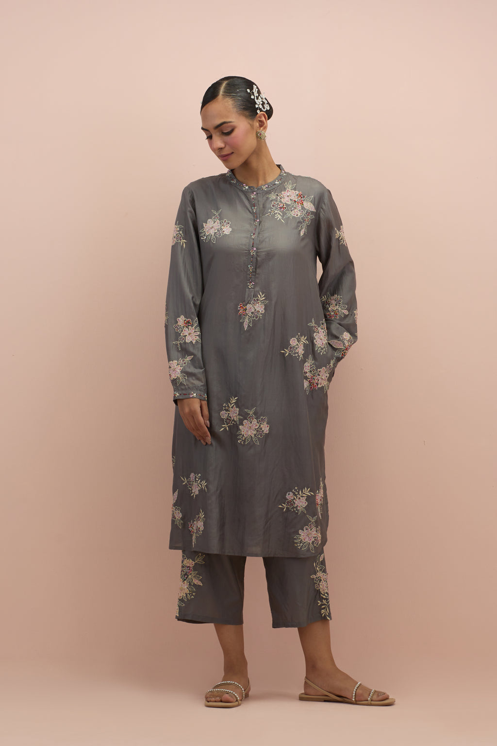 Iron grey silk short shirt kurta with all-over hand block printed appliqué, highlighted with sequins and multi colored beads, paired with iron grey silk ankle length straight pants with hand block printed appliqué motifs at the sides.