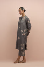 Iron grey silk short shirt kurta with all-over hand block printed appliqué, highlighted with sequins and multi colored beads, paired with iron grey silk ankle length straight pants with hand block printed appliqué motifs at the sides.