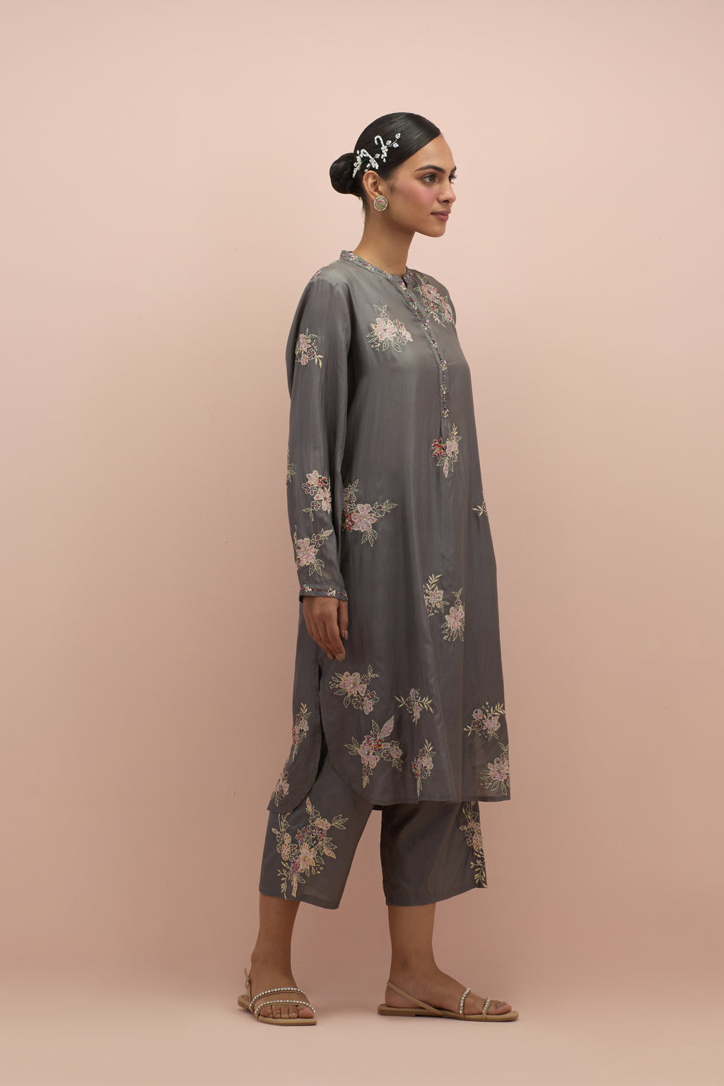 Iron grey silk short shirt kurta with all-over hand block printed appliqué, highlighted with sequins and multi colored beads, paired with iron grey silk ankle length straight pants with hand block printed appliqué motifs at the sides.