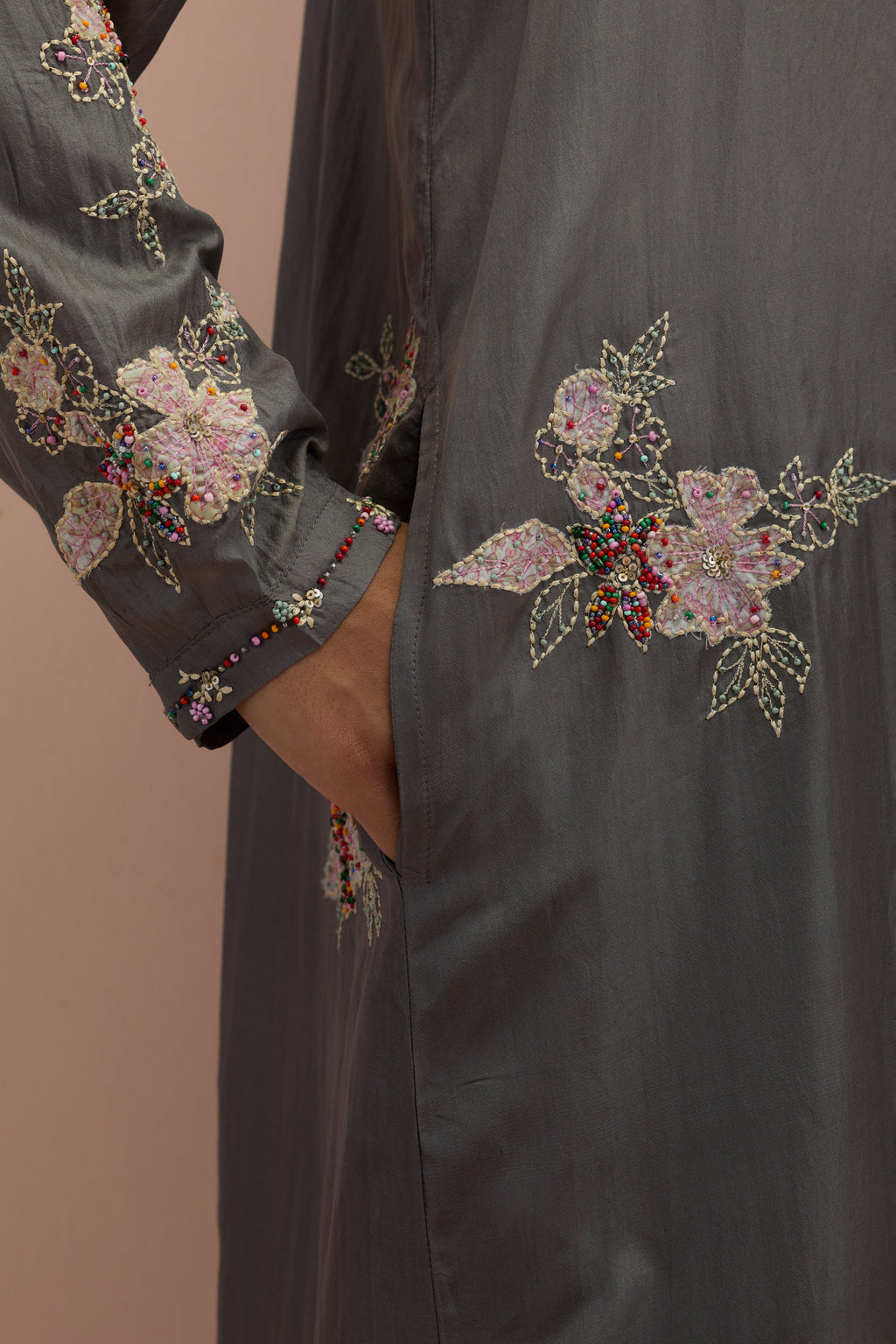 Iron grey silk short shirt kurta with all-over hand block printed appliqué, highlighted with sequins and multi colored beads, paired with iron grey silk ankle length straight pants with hand block printed appliqué motifs at the sides.