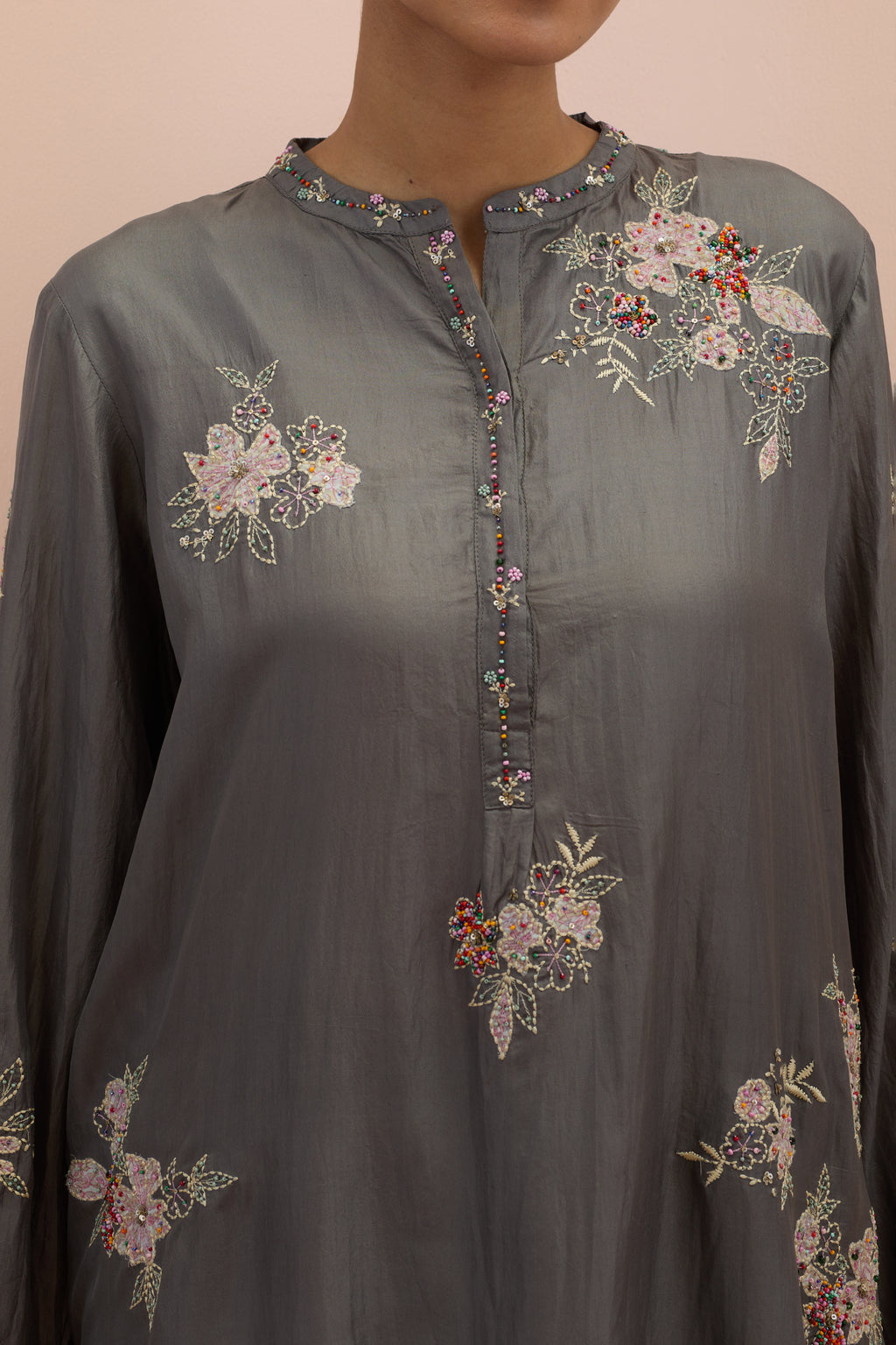 Iron grey silk short shirt kurta with all-over hand block printed appliqué, highlighted with sequins and multi colored beads, paired with iron grey silk ankle length straight pants with hand block printed appliqué motifs at the sides.