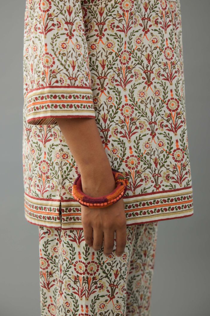 Red & green cotton short top with all-over hand block print, paired with blue and pink hand block printed cotton straight pants.