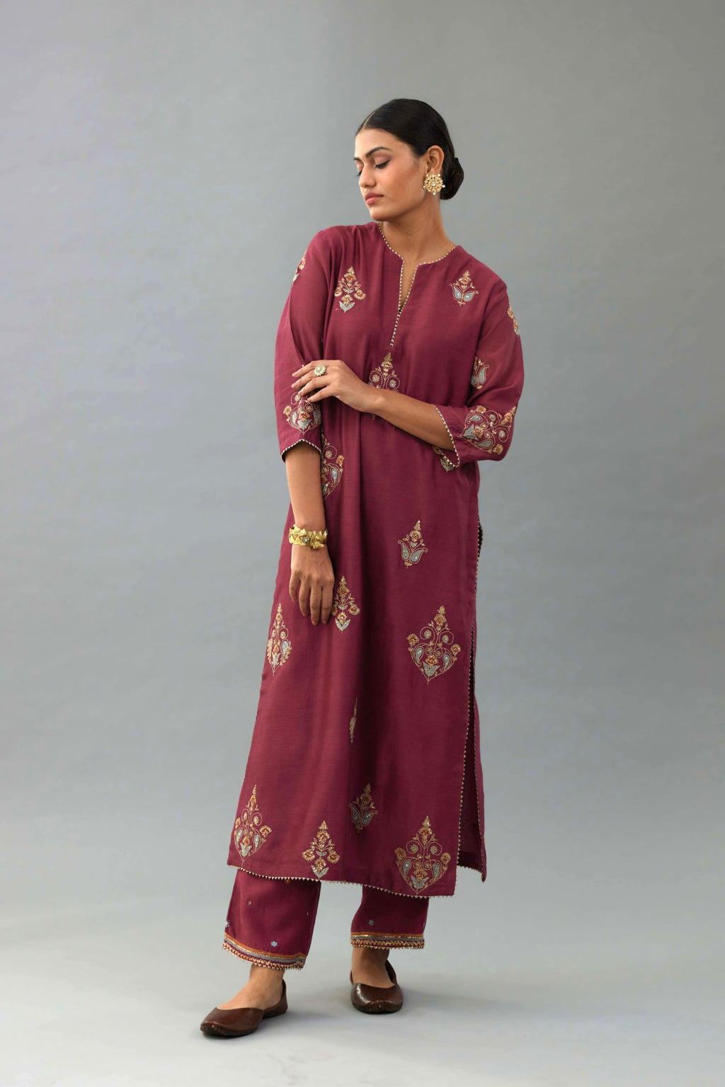 Wine silk chanderi straight kurta set with zari, dori and contrast silk thread embroidered bootas, highlighted with gold sequins work.