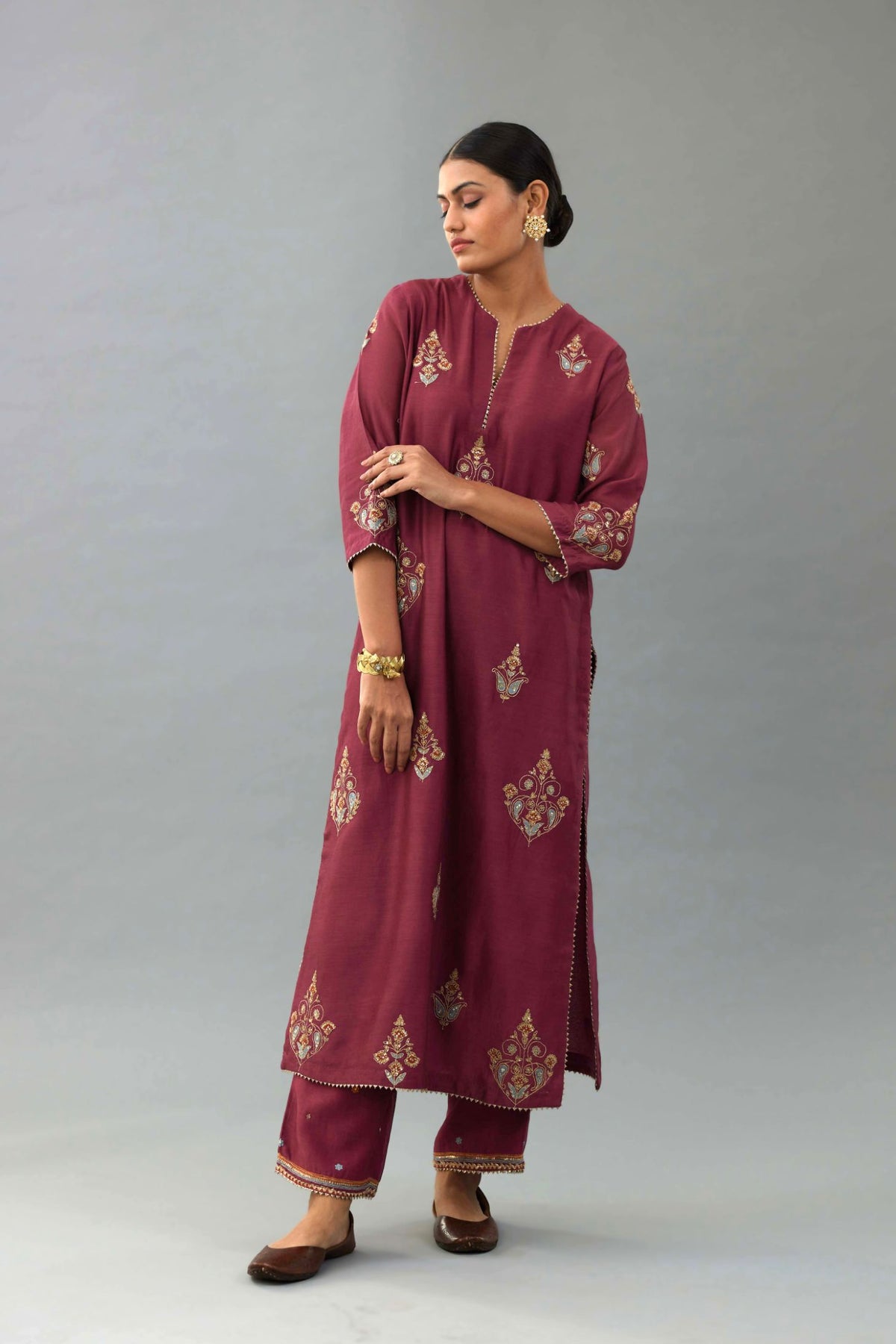 Wine silk chanderi straight kurta set with zari, dori and contrast silk thread embroidered bootas, highlighted with gold sequins work.