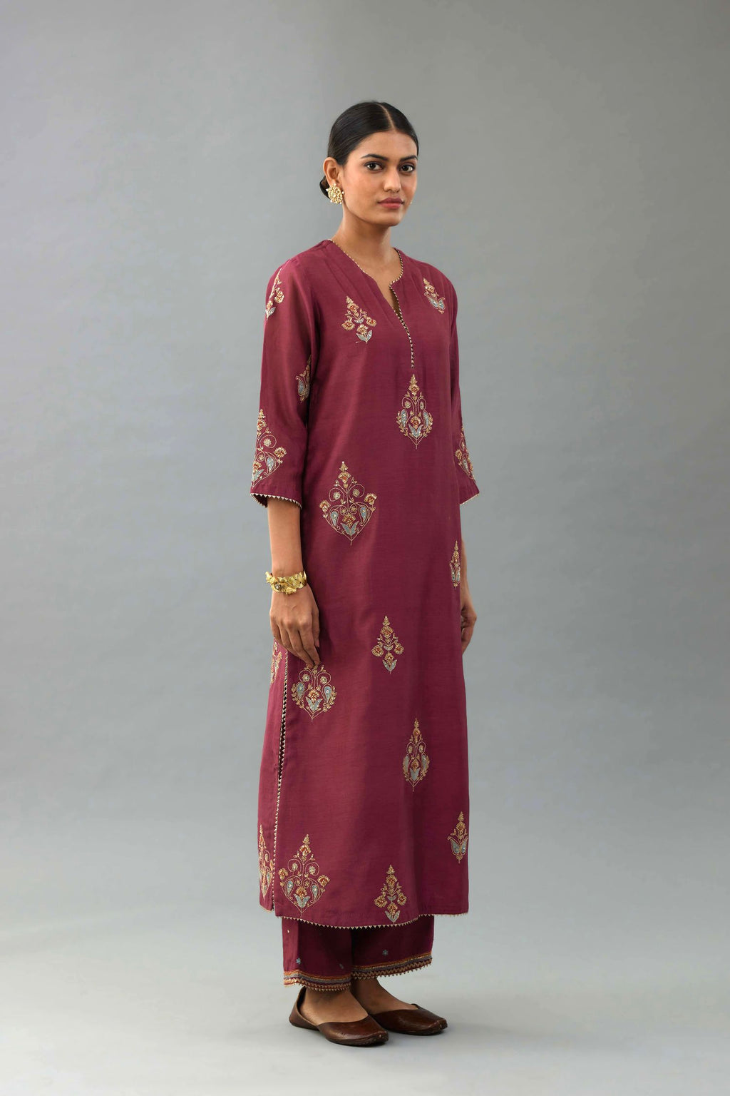 Wine silk chanderi straight kurta set with zari, dori and contrast silk thread embroidered bootas, highlighted with gold sequins work.
