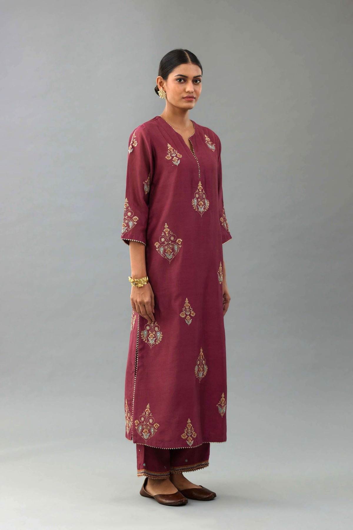 Wine silk chanderi straight kurta set with zari, dori and contrast silk thread embroidered bootas, highlighted with gold sequins work.