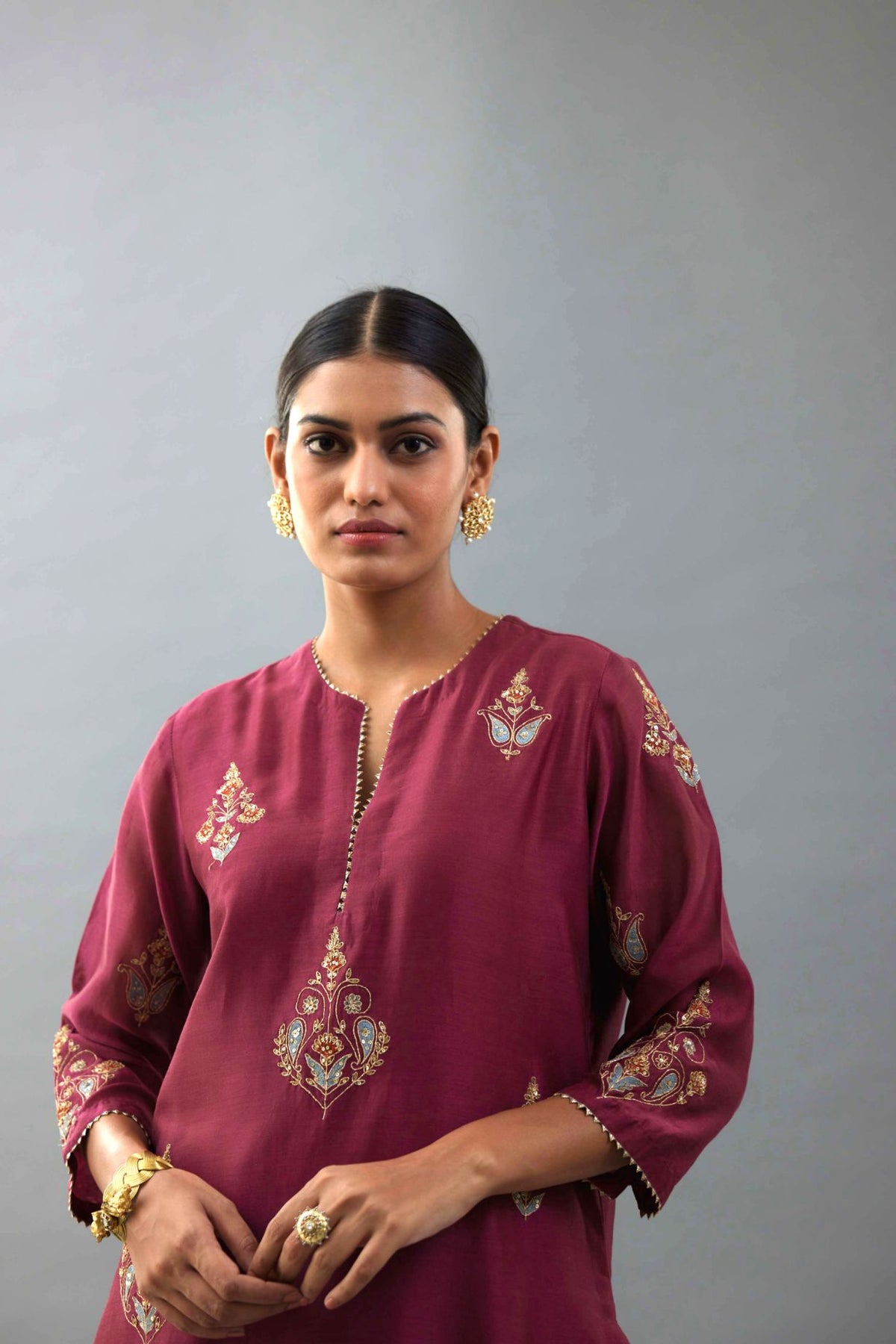 Wine silk chanderi straight kurta set with zari, dori and contrast silk thread embroidered bootas, highlighted with gold sequins work.