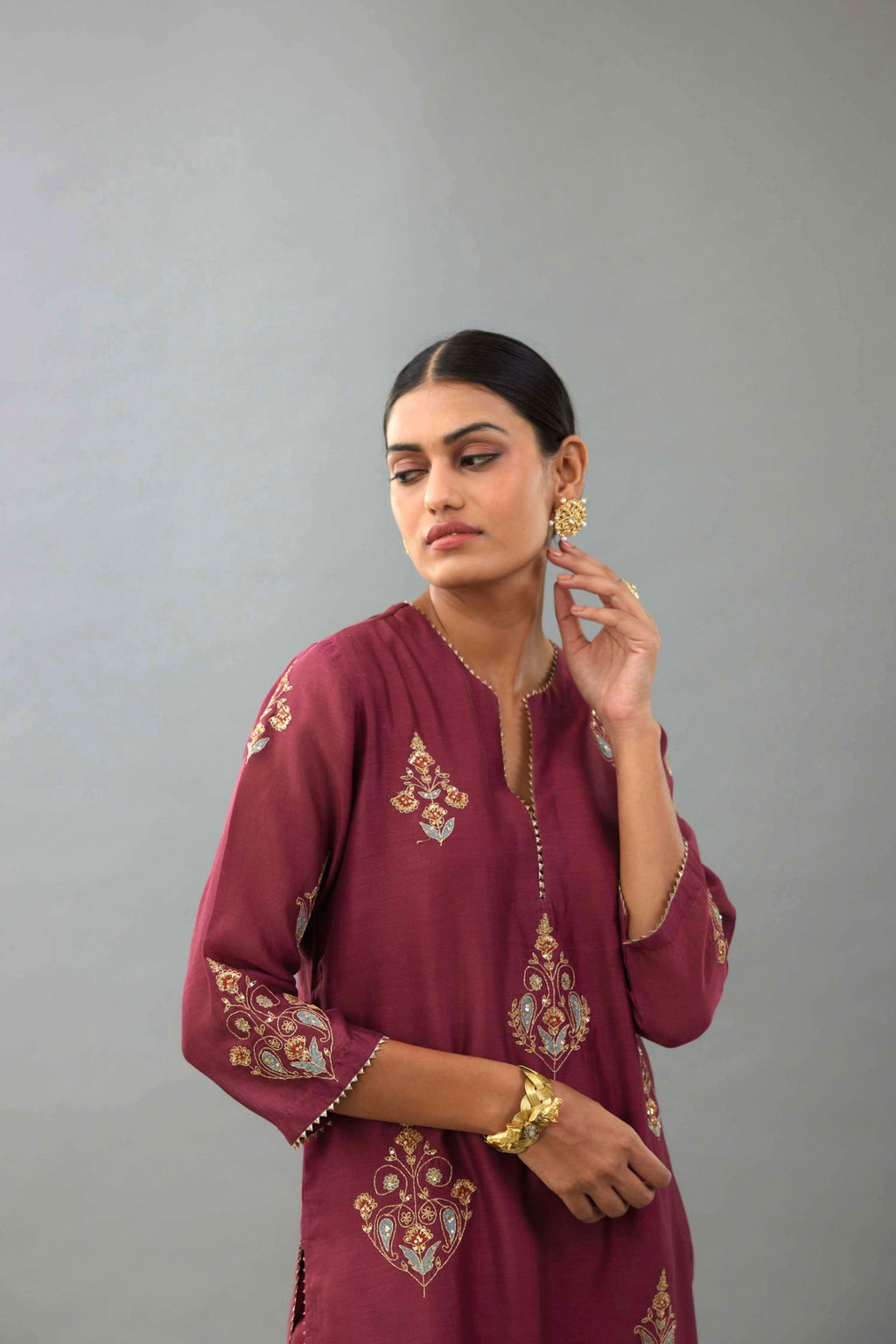 Wine silk chanderi straight kurta set with zari, dori and contrast silk thread embroidered bootas, highlighted with gold sequins work.