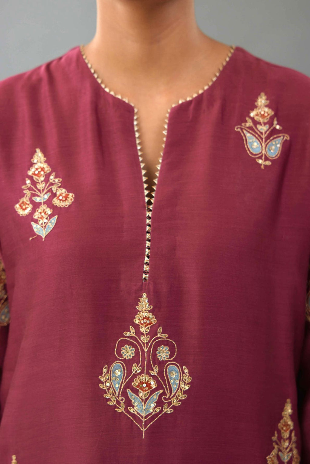 Wine silk chanderi straight kurta set with zari, dori and contrast silk thread embroidered bootas, highlighted with gold sequins work.