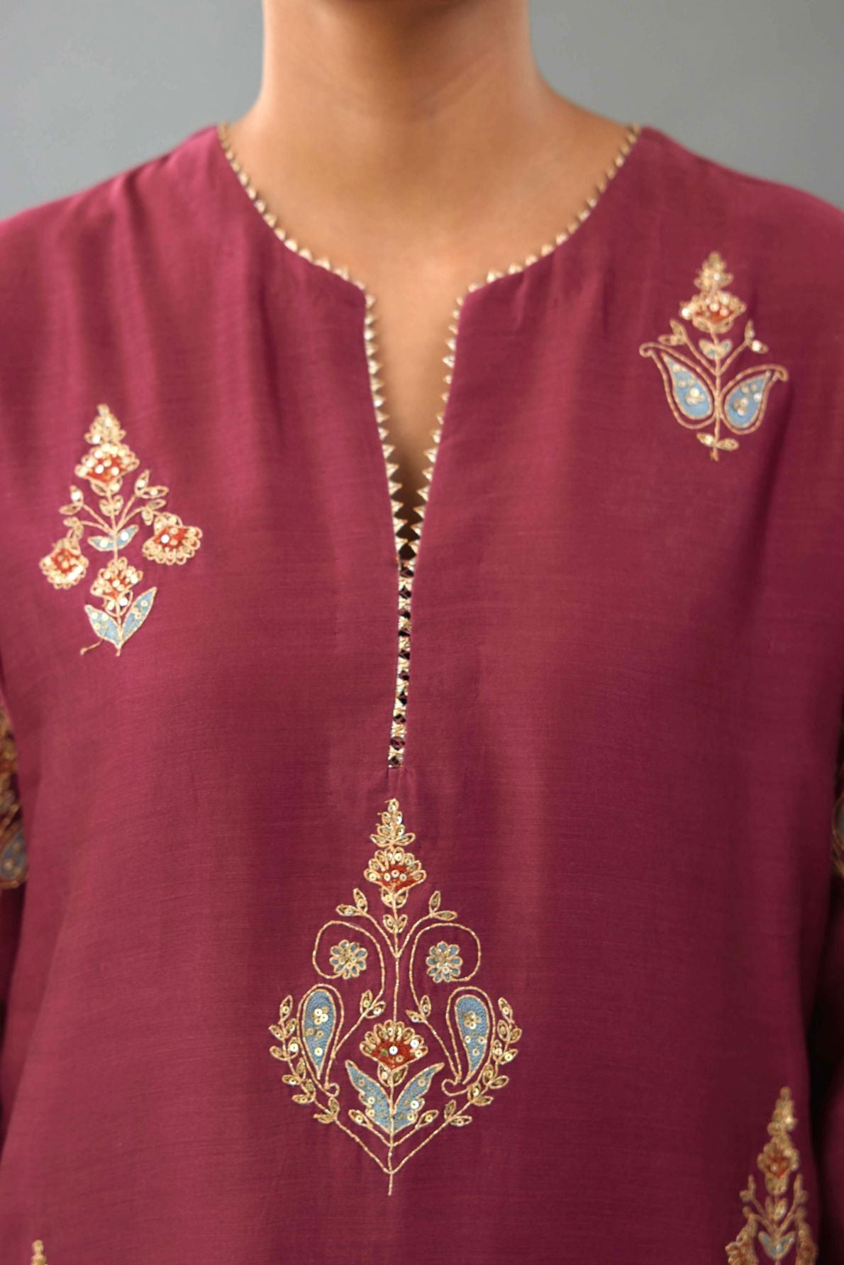Wine silk chanderi straight kurta set with zari, dori and contrast silk thread embroidered bootas, highlighted with gold sequins work.