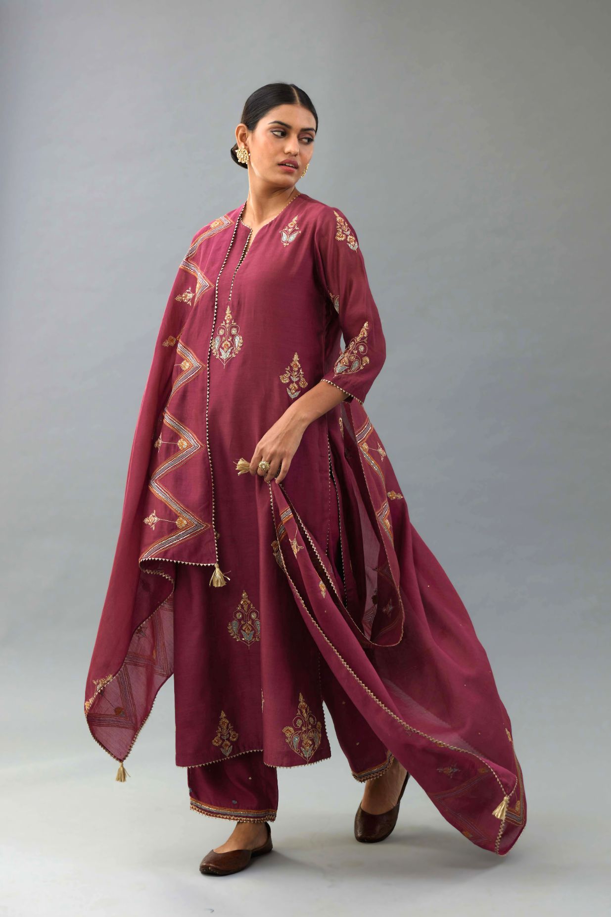 Wine silk chanderi straight kurta set with zari, dori and contrast silk thread embroidered bootas, highlighted with gold sequins work.