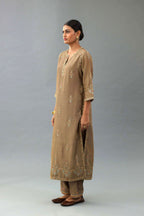 Taupe silk chanderi straight kurta set with all-over zari, dori and contrast silk thread embroidery, highlighted with gold sequins work.