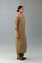 Taupe silk chanderi straight kurta set with all-over zari, dori and contrast silk thread embroidery, highlighted with gold sequins work.