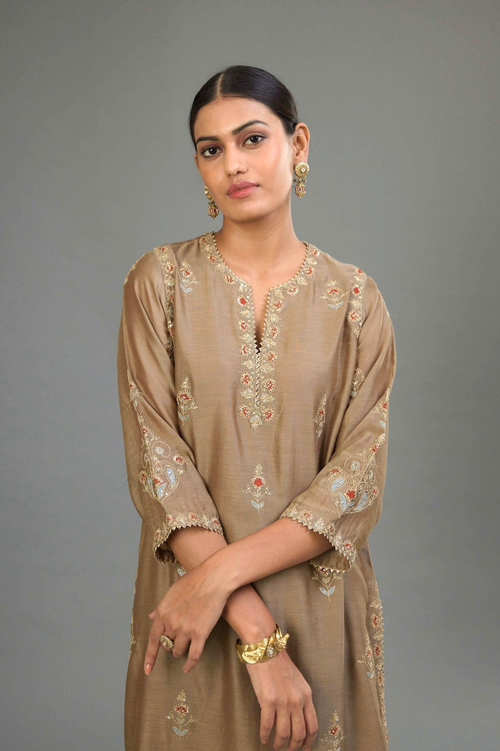 Taupe silk chanderi straight kurta set with all-over zari, dori and contrast silk thread embroidery, highlighted with gold sequins work.