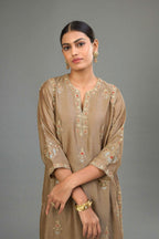 Taupe silk chanderi straight kurta set with all-over zari, dori and contrast silk thread embroidery, highlighted with gold sequins work.