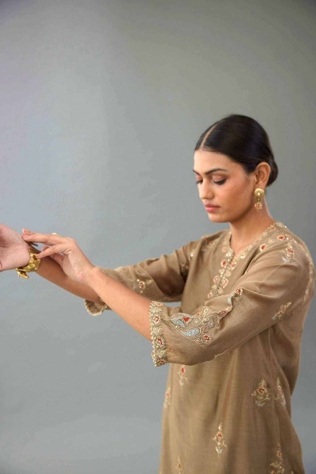 Taupe silk chanderi straight kurta set with all-over zari, dori and contrast silk thread embroidery, highlighted with gold sequins work.