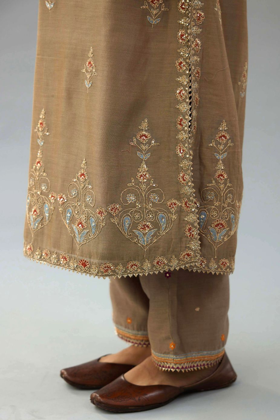 Taupe silk chanderi straight kurta set with all-over zari, dori and contrast silk thread embroidery, highlighted with gold sequins work.
