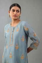 Light blue silk chanderi A-line short kurta set with dori and contrast silk thread embroidery, highlighted with gold sequins work.