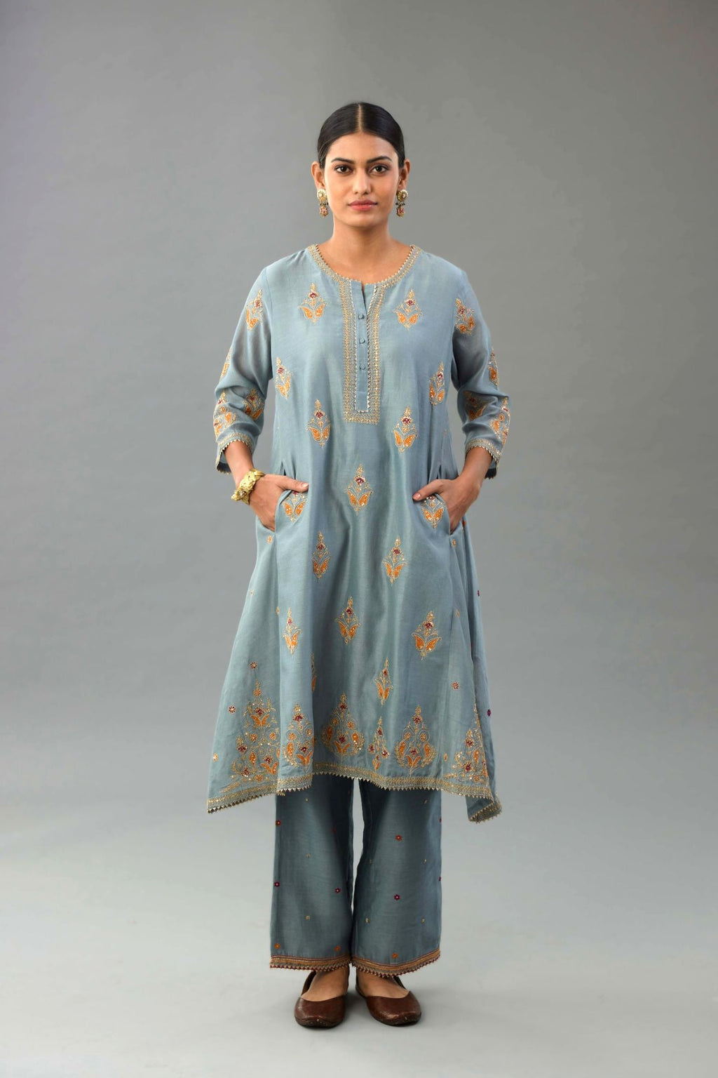Light blue silk chanderi A-line short kurta set with dori and contrast silk thread embroidery, highlighted with gold sequins work.