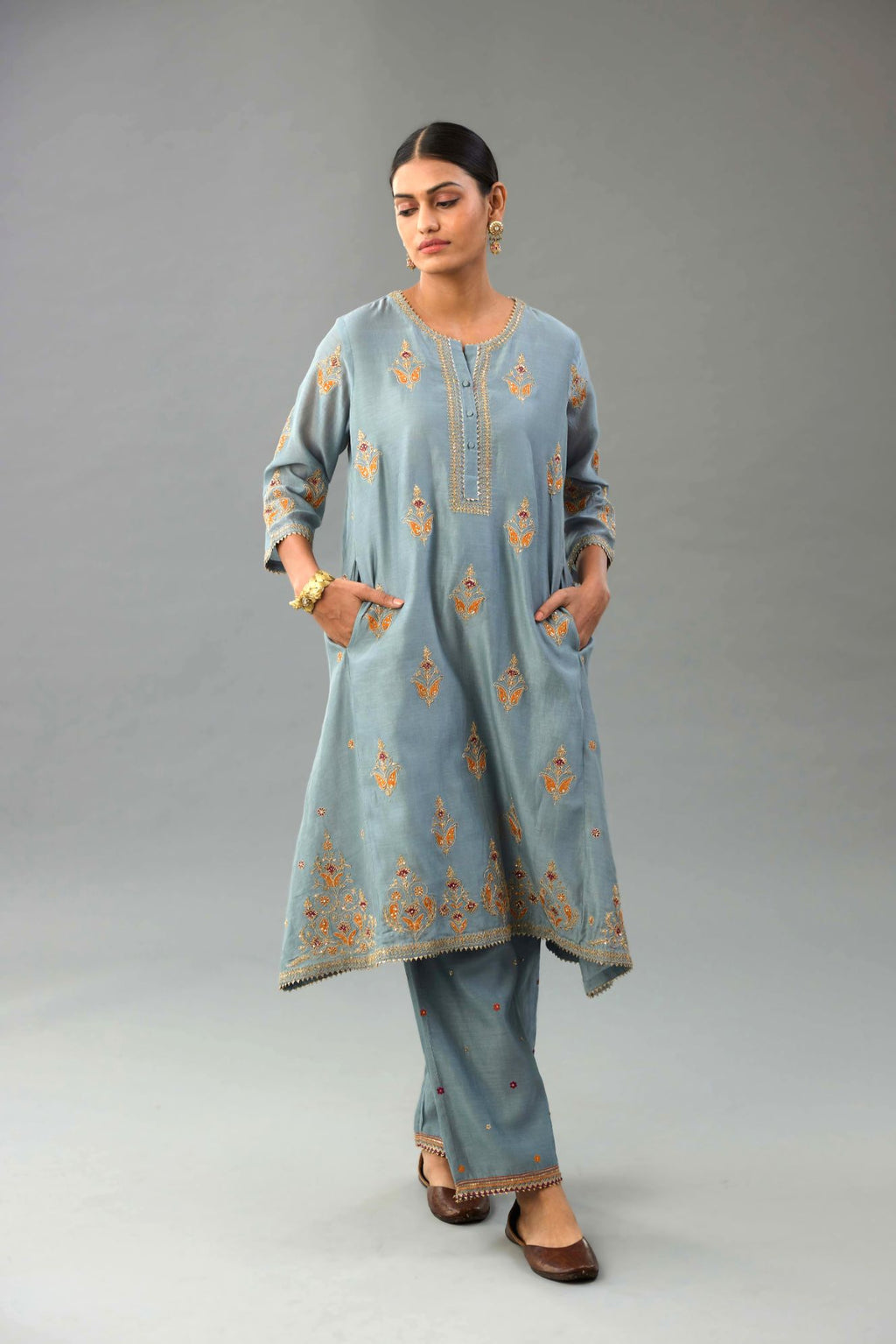 Light blue silk chanderi A-line short kurta set with dori and contrast silk thread embroidery, highlighted with gold sequins work.
