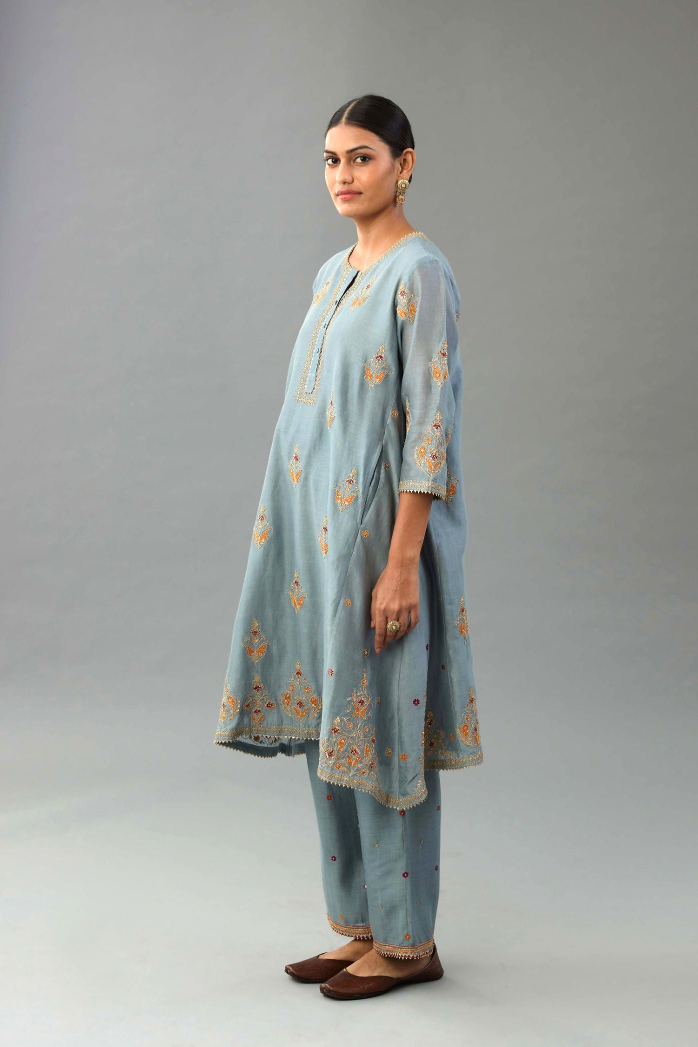 Light blue silk chanderi A-line short kurta set with dori and contrast silk thread embroidery, highlighted with gold sequins work.