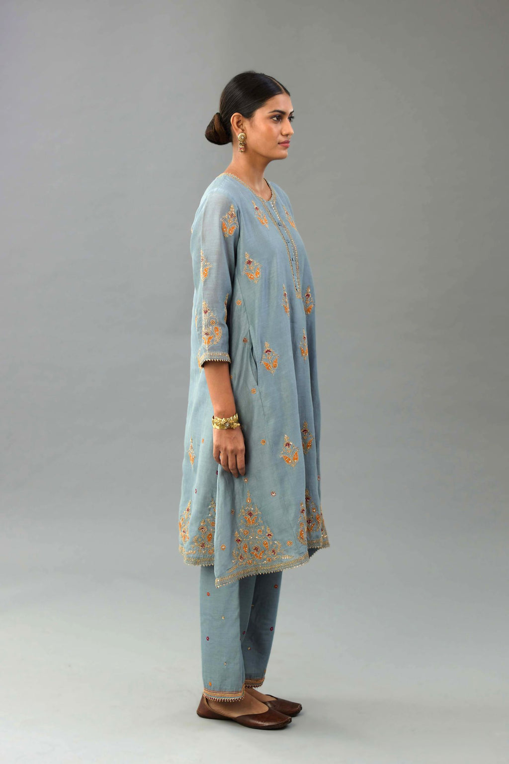 Light blue silk chanderi A-line short kurta set with dori and contrast silk thread embroidery, highlighted with gold sequins work.