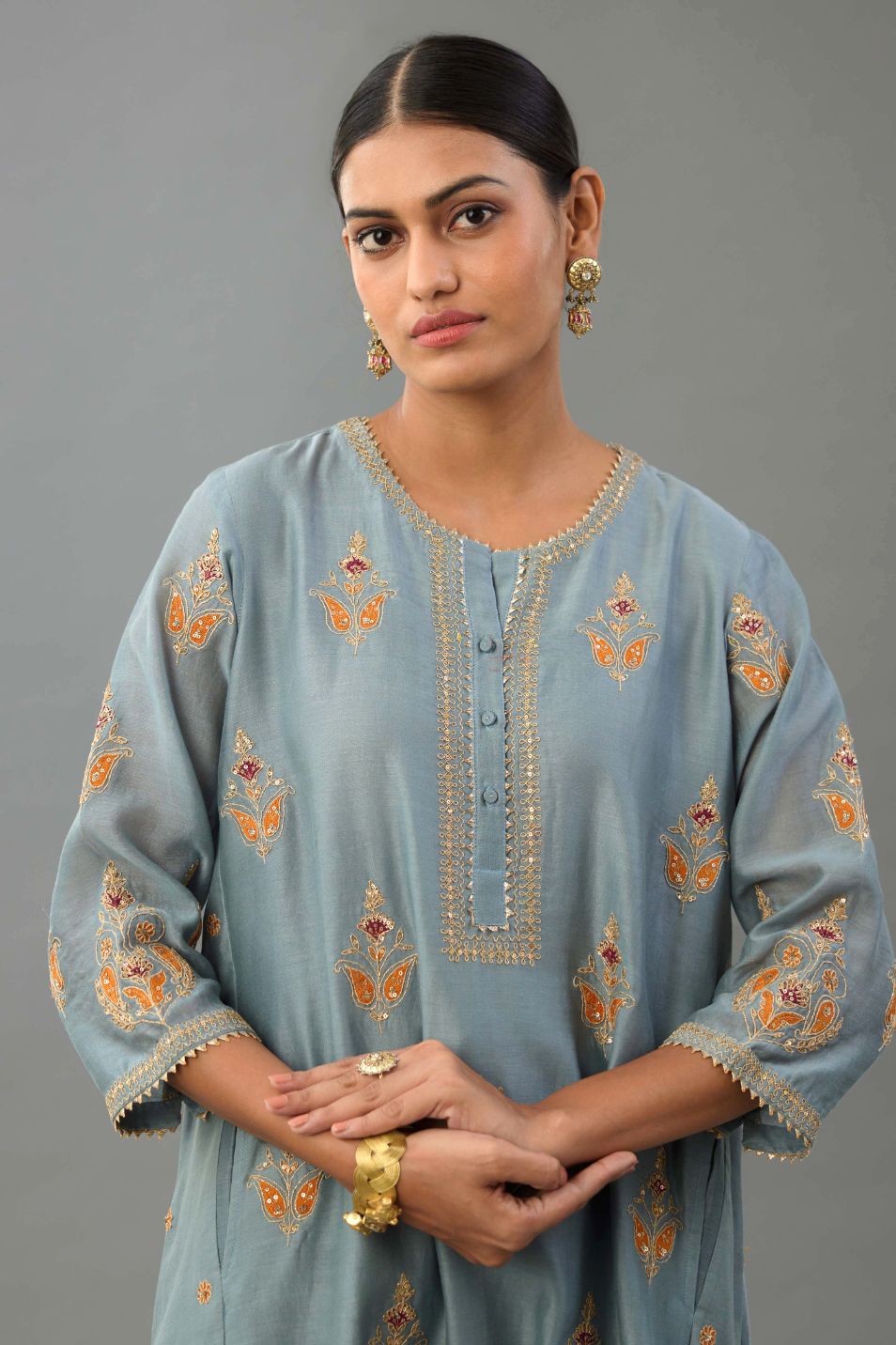 Light blue silk chanderi A-line short kurta set with dori and contrast silk thread embroidery, highlighted with gold sequins work.
