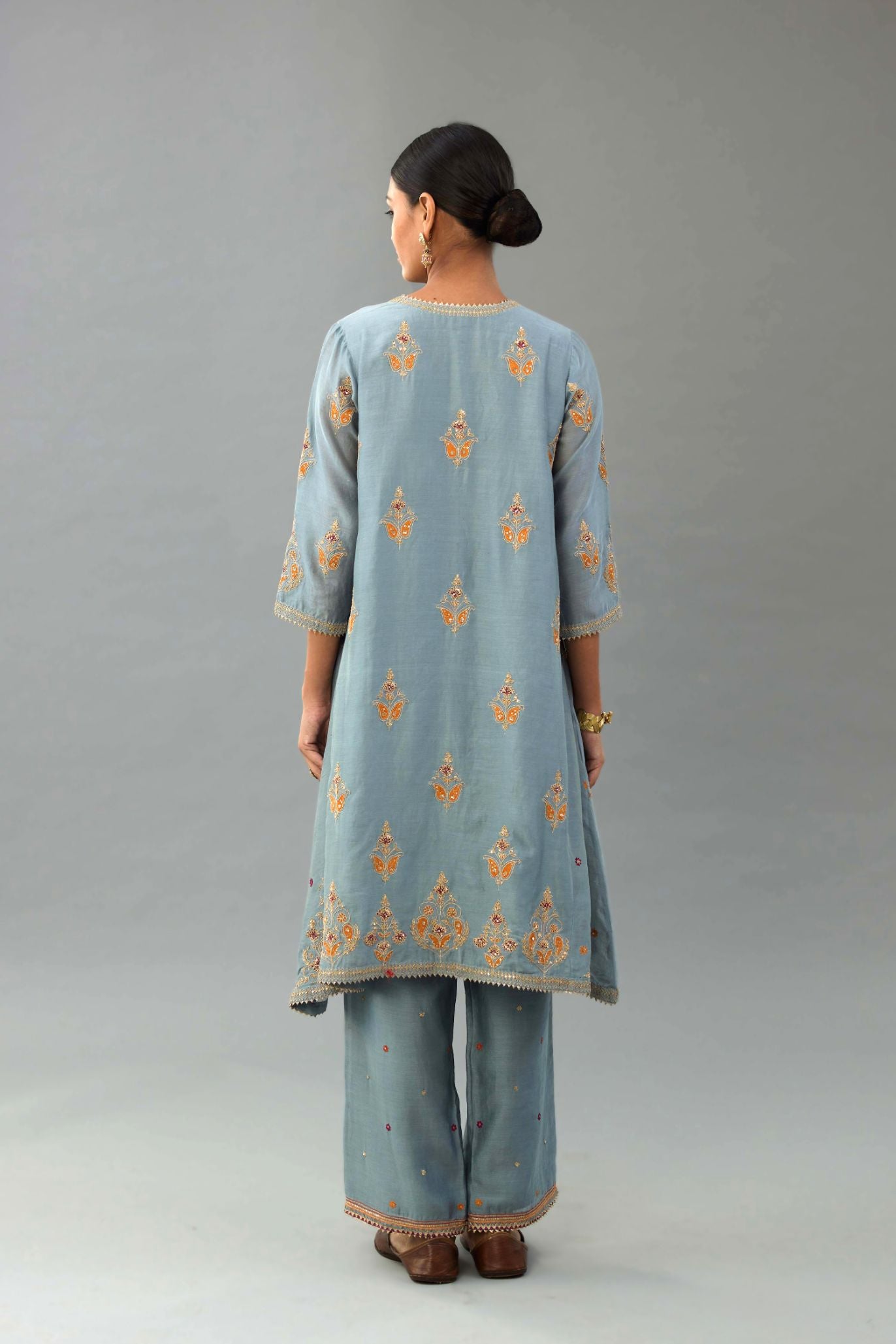 Light blue silk chanderi A-line short kurta set with dori and contrast silk thread embroidery, highlighted with gold sequins work.