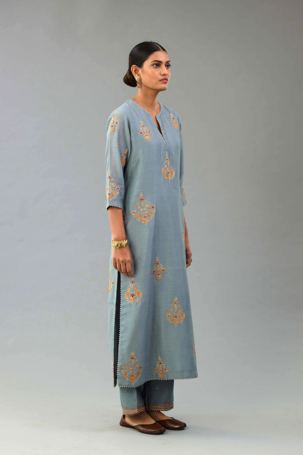Light blue silk chanderi straight kurta set with zari, dori and contrast silk thread embroidered bootas, highlighted with gold sequins work.