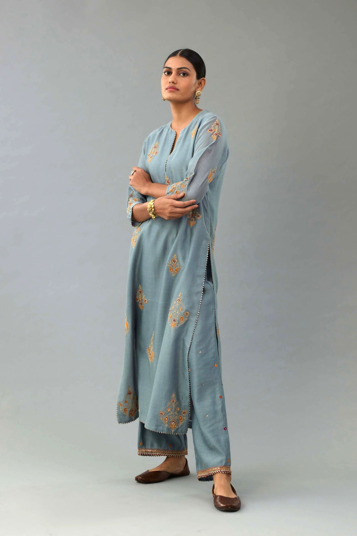 Light blue silk chanderi straight kurta set with zari, dori and contrast silk thread embroidered bootas, highlighted with gold sequins work.