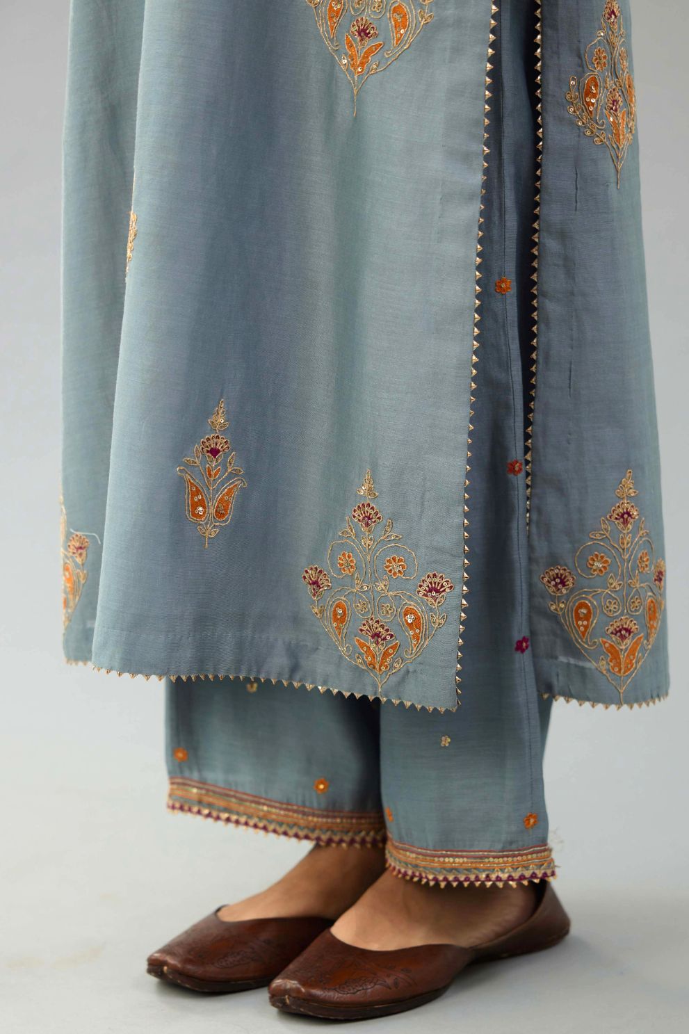 Light blue silk chanderi straight kurta set with zari, dori and contrast silk thread embroidered bootas, highlighted with gold sequins work.