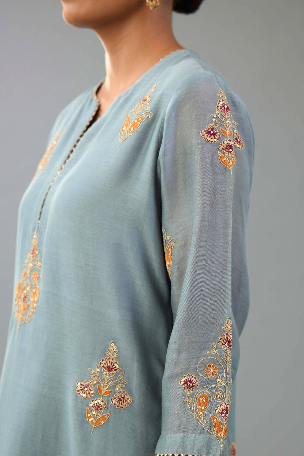 Light blue silk chanderi straight kurta set with zari, dori and contrast silk thread embroidered bootas, highlighted with gold sequins work.