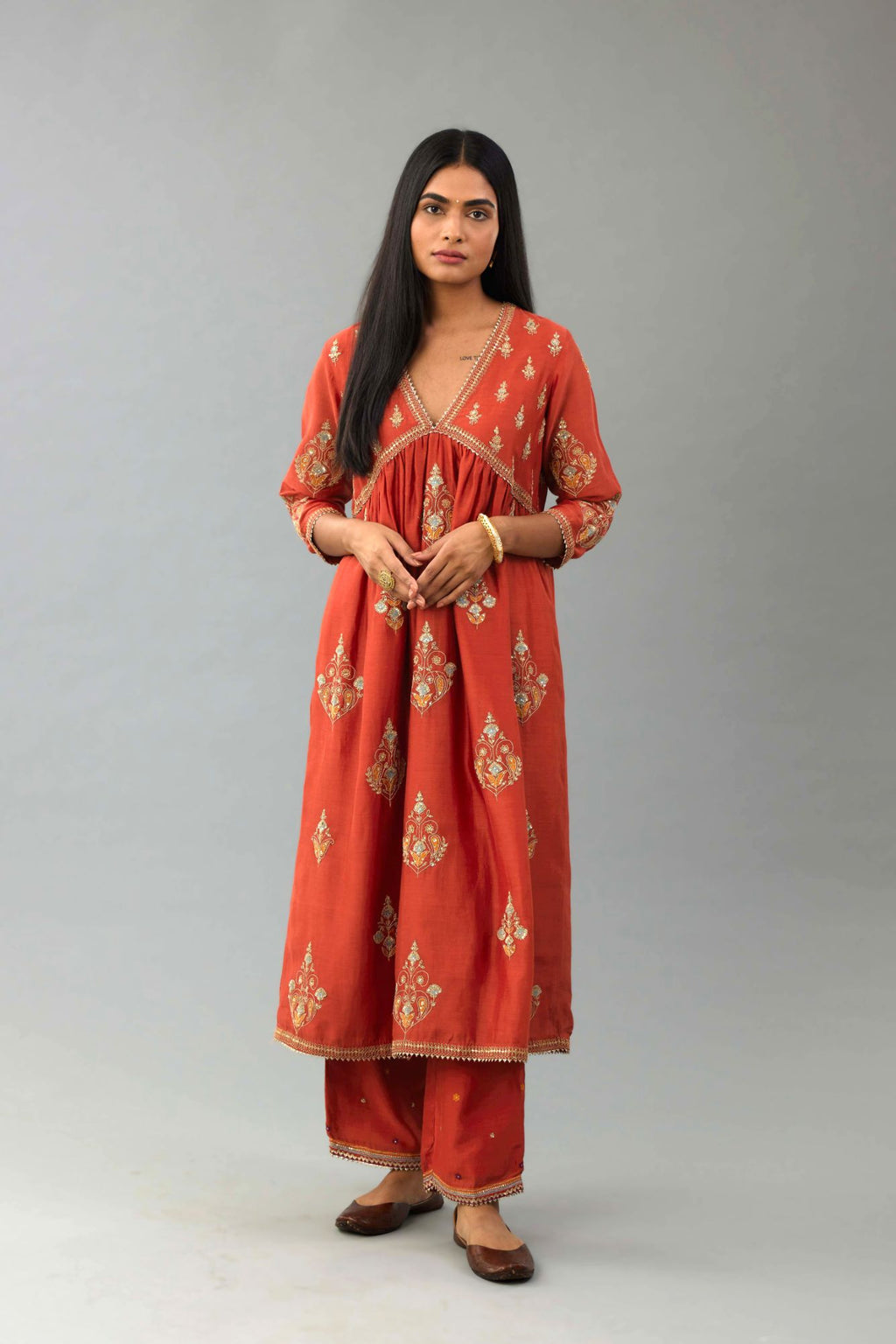 Rust silk chanderi kurta-dress set with all-over zari, dori and contrast silk thread embroidery, highlighted with gold sequins work.