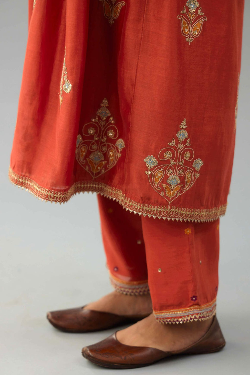 Rust silk chanderi kurta-dress set with all-over zari, dori and contrast silk thread embroidery, highlighted with gold sequins work.